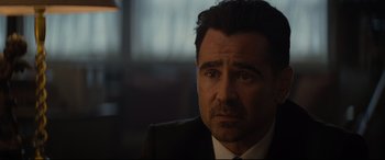 Movie still from “Artemis Fowl” (2020), directed by Kenneth Branagh – A person wearing a suit and tie; Close Up shot, Over the shoulder angle