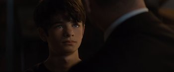 Movie still from “Artemis Fowl” (2020), directed by Kenneth Branagh – A young boy with blue eyes stares into the distance; Close Up shot, Over the shoulder angle