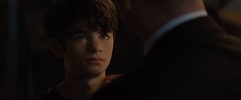 Movie still from “Artemis Fowl” (2020), directed by Kenneth Branagh – A young boy with blue eyes stares into the camera; Close Up shot, Over the shoulder angle