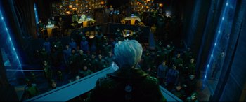 Movie still from “Artemis Fowl” (2020), directed by Kenneth Branagh – A crowd of people sitting in front of a stage; Wide shot, High angle