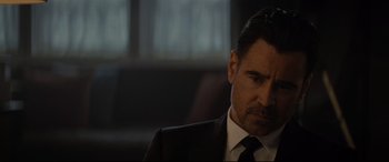 Movie still from “Artemis Fowl” (2020), directed by Kenneth Branagh – A person wearing a suit and tie; Close Up shot, Over the shoulder angle