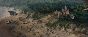Movie still from “Artemis Fowl” (2020), directed by Kenneth Branagh – An aerial view of an area that has a lot of trees and rocks on it; Extreme Wide shot, High angle