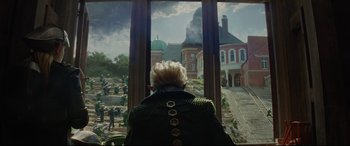 Movie still from “Artemis Fowl” (2020), directed by Kenneth Branagh – An older woman looking out a window at a castle; Wide shot, Low angle