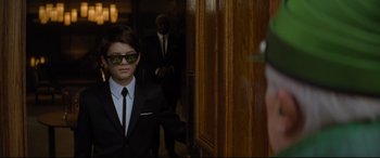 Movie still from “Artemis Fowl” (2020), directed by Kenneth Branagh – A young boy in a suit and sunglasses; Medium shot, Over the shoulder angle