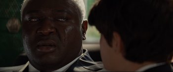 Movie still from “Artemis Fowl” (2020), directed by Kenneth Branagh – A man and a boy are sitting in a car; Close Up shot, Over the shoulder angle