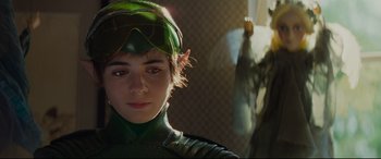 Movie still from “Artemis Fowl” (2020), directed by Kenneth Branagh – A person wearing a green costume; Close Up shot, Over the shoulder angle