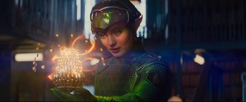 Movie still from “Artemis Fowl” (2020), directed by Kenneth Branagh – A person in a green outfit holding a fire; Medium shot, Over the shoulder angle
