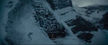 Movie still from “Artemis Fowl” (2020), directed by Kenneth Branagh – A person standing in the snow near a cliff; Extreme Wide shot, High angle