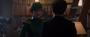 Movie still from “Artemis Fowl” (2020), directed by Kenneth Branagh – A woman in a green suit and a man in a black suit; Close Up shot, Over the shoulder angle