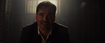 Movie still from “Artemis Fowl” (2020), directed by Kenneth Branagh – A person wearing a suit and tie; Close Up shot, Over the shoulder angle