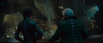 Movie still from “Artemis Fowl” (2020), directed by Kenneth Branagh – Two people looking out over a city at night; Medium shot, Over the shoulder angle