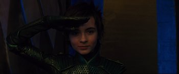 Movie still from “Artemis Fowl” (2020), directed by Kenneth Branagh – A young person wearing a green outfit with a snake on his head; Close Up shot, Low angle