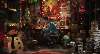 Movie still from “Arthur Christmas” (2011), directed by Barry Cook – A man sitting at a desk in front of a christmas tree; Wide shot, High angle