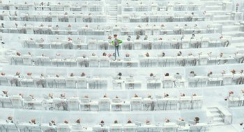 Movie still from “Arthur Christmas” (2011), directed by Barry Cook – A man standing in a room full of tables; Extreme Wide shot, Overhead angle