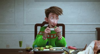 Movie still from “Arthur Christmas” (2011), directed by Barry Cook – A man sitting at a table with a tray of food in front of him; Medium shot, Over the shoulder angle