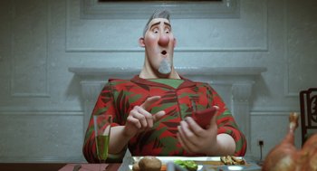 Movie still from “Arthur Christmas” (2011), directed by Barry Cook – An animated man sitting at a table with food in front of him; Medium shot, Over the shoulder angle