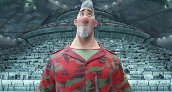 Movie still from “Arthur Christmas” (2011), directed by Barry Cook – An animated man in a red and green shirt is standing in an empty stadium; Medium shot, Low angle