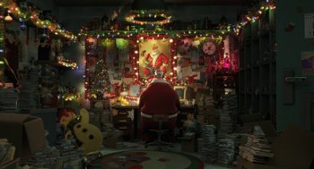 Movie still from “Arthur Christmas” (2011), directed by Barry Cook – A man in a santa suit sitting at a desk in front of christmas lights; Extreme Wide shot, High angle