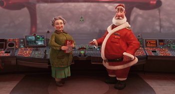 Movie still from “Arthur Christmas” (2011), directed by Barry Cook – An old woman standing next to an old man dressed as santa claus; Medium shot, High angle
