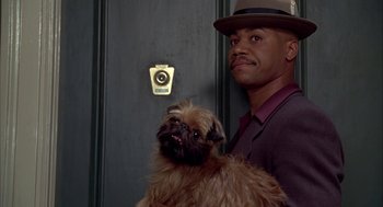 Movie still from “As Good as It Gets” (1997), directed by James L. Brooks – A man holding a small brown dog in his arms; Close Up shot, Over the shoulder angle