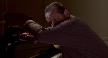Movie still from “As Good as It Gets” (1997), directed by James L. Brooks – A man is playing the piano in a dark room; Close Up shot, Low angle