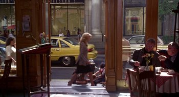 Movie still from “As Good as It Gets” (1997), directed by James L. Brooks – A woman walking down the sidewalk in front of a store; Wide shot, High angle