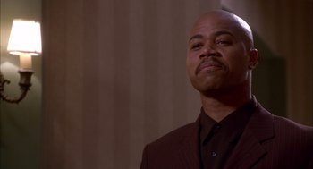 Movie still from “As Good as It Gets” (1997), directed by James L. Brooks – A bald man in a brown suit looking to his left; Close Up shot, Low angle