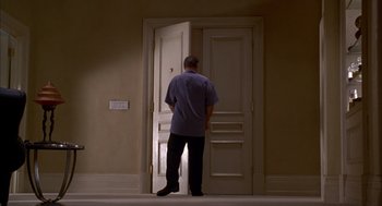 Movie still from “As Good as It Gets” (1997), directed by James L. Brooks – A man standing in front of an open door; Wide shot, Low angle