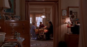 Movie still from “As Good as It Gets” (1997), directed by James L. Brooks – A group of people sitting at a table in a room; Wide shot, High angle