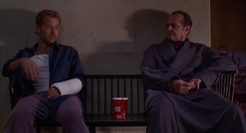 Movie still from “As Good as It Gets” (1997), directed by James L. Brooks – Two people sitting on a bench with one arm in a cast and the other arm in a cast; Medium shot, Low angle