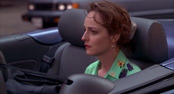 Movie still from “As Good as It Gets” (1997), directed by James L. Brooks – A woman sitting in the back seat of a car; Close Up shot, Over the shoulder angle