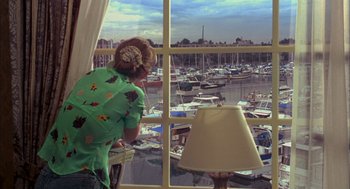 Movie still from “As Good as It Gets” (1997), directed by James L. Brooks – A woman looking out of a window at a marina; Wide shot, High angle