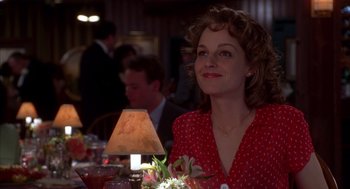 Movie still from “As Good as It Gets” (1997), directed by James L. Brooks – A woman sitting at a table with a lamp in front of her; Medium shot, Over the shoulder angle
