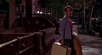 Movie still from “As Good as It Gets” (1997), directed by James L. Brooks – A woman walking down the street with her luggage; Wide shot, Over the shoulder angle