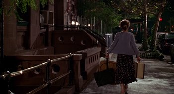 Movie still from “As Good as It Gets” (1997), directed by James L. Brooks – A woman walking down the street holding a purse; Wide shot, Low angle