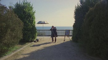 A man taking a picture of the ocean with a camera