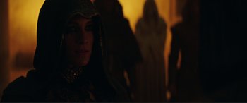 Movie still from “Assassin's Creed” (2016), directed by Justin Kurzel – A woman in a hooded dress in a dark room; Close Up shot, Over the shoulder angle