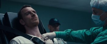 Movie still from “Assassin's Creed” (2016), directed by Justin Kurzel – A man is being fitted for a tie by a woman; Close Up shot, Over the shoulder angle