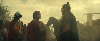 Movie still from “Assassin's Creed” (2016), directed by Justin Kurzel – Two men in medieval garb talking to each other in front of a horse; Medium shot, Over the shoulder angle