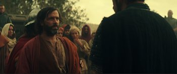 Movie still from “Assassin's Creed” (2016), directed by Justin Kurzel – A group of men in robes and headgear stand in a line; Medium shot, Over the shoulder angle