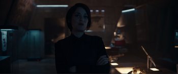 Movie still from “Assassin's Creed” (2016), directed by Justin Kurzel – A woman standing in the dark with her arms crossed; Medium shot, Over the shoulder angle