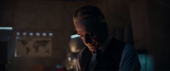 Movie still from “Assassin's Creed” (2016), directed by Justin Kurzel – An older man wearing a suit and tie; Close Up shot, Over the shoulder angle
