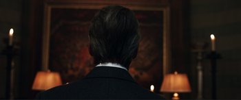 Movie still from “Assassin's Creed” (2016), directed by Justin Kurzel – A man in a black suit and white collar; Close Up shot, Over the shoulder angle