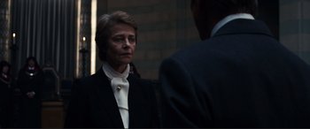 Movie still from “Assassin's Creed” (2016), directed by Justin Kurzel – A woman wearing a suit and a white tie; Close Up shot, Over the shoulder angle