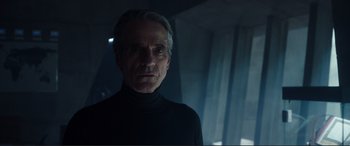 Movie still from “Assassin's Creed” (2016), directed by Justin Kurzel – An older man wearing a black shirt in a dark room; Close Up shot, Low angle