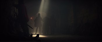 Movie still from “Assassin's Creed” (2016), directed by Justin Kurzel – A group of people standing in a dark room; Wide shot, Low angle