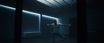 Movie still from “Assassin's Creed” (2016), directed by Justin Kurzel – A man in a white shirt is in a dark room; Wide shot, Low angle