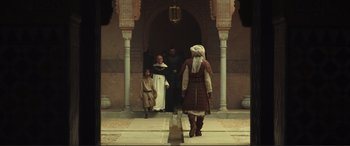 Movie still from “Assassin's Creed” (2016), directed by Justin Kurzel – An old man in a medieval outfit walking down the street; Wide shot, Low angle