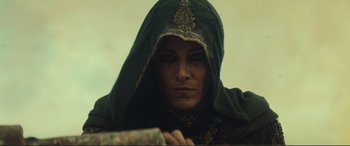 Movie still from “Assassin's Creed” (2016), directed by Justin Kurzel – A woman in a green hooded jacket looking at the camera; Close Up shot, Low angle