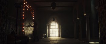 Movie still from “Assassin's Creed” (2016), directed by Justin Kurzel – A person is standing in front of an arched window; Extreme Wide shot, Low angle